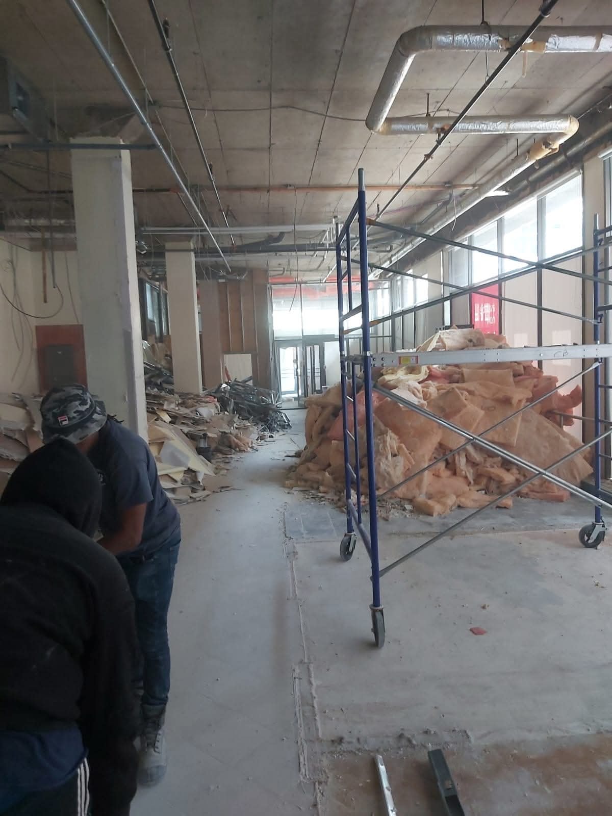 Construction workers inside building under renovation with scaffolding